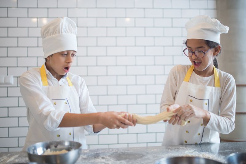 Pizza factory team member crafting fresh dough by hand